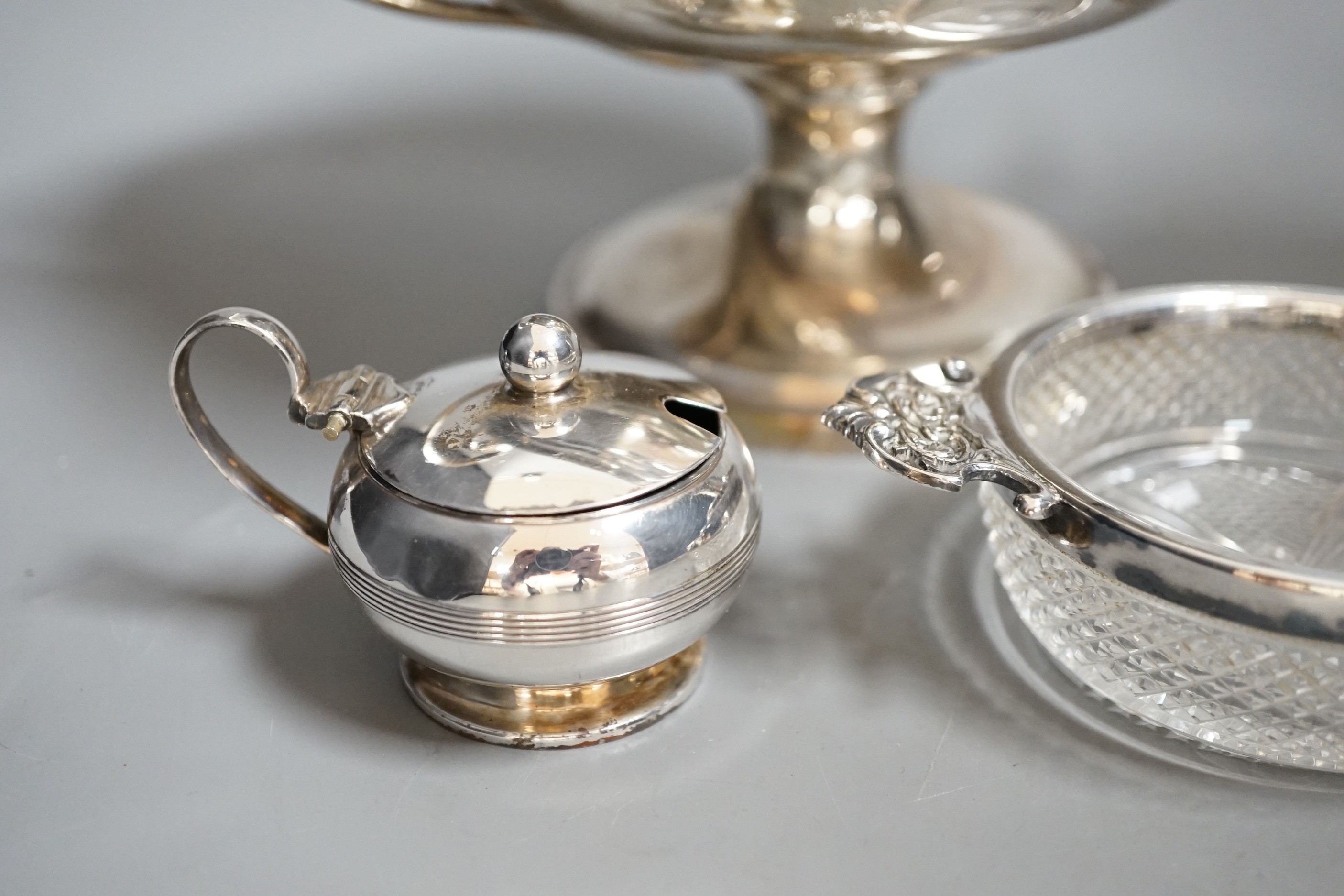 A group of assorted small silver items to include a posy vase, silver-mounted cut glass quaich, a twin-handled silver cup and three condiments.